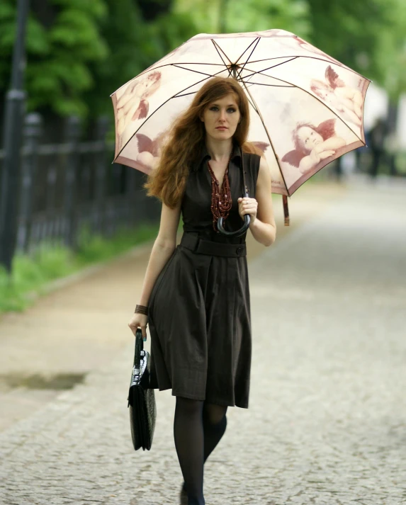 woman holding an umbrella walking down the street