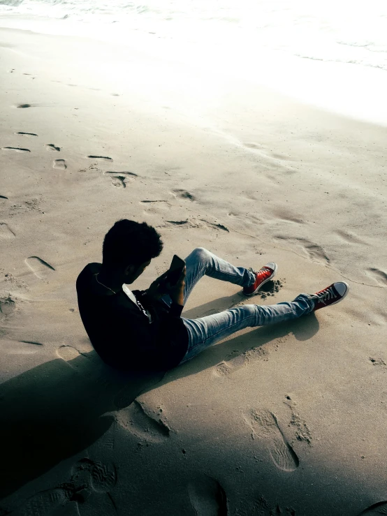 a woman sits on the beach with a guitar