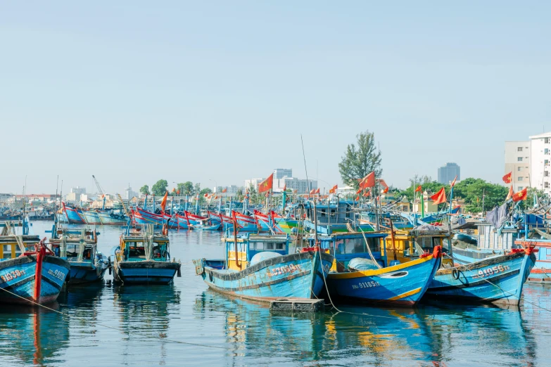 many blue boats docked in water next to buildings