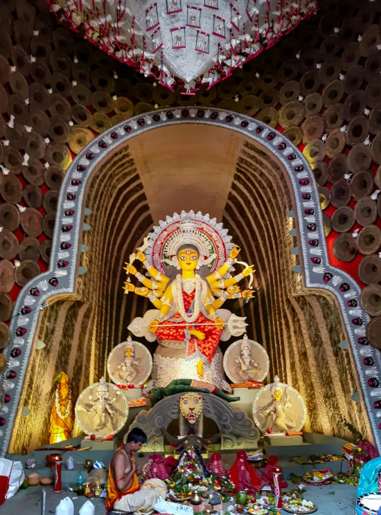 statue of buddha in front of elaborate decorated ceiling