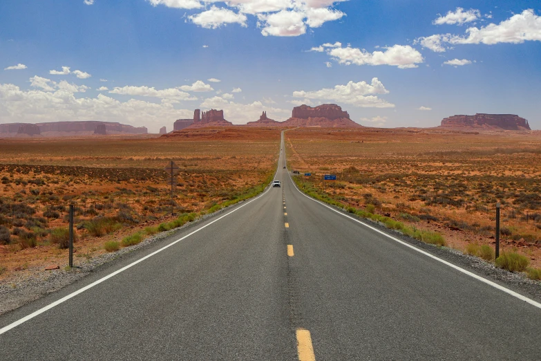 a long stretch of deserted road with mountains in the background