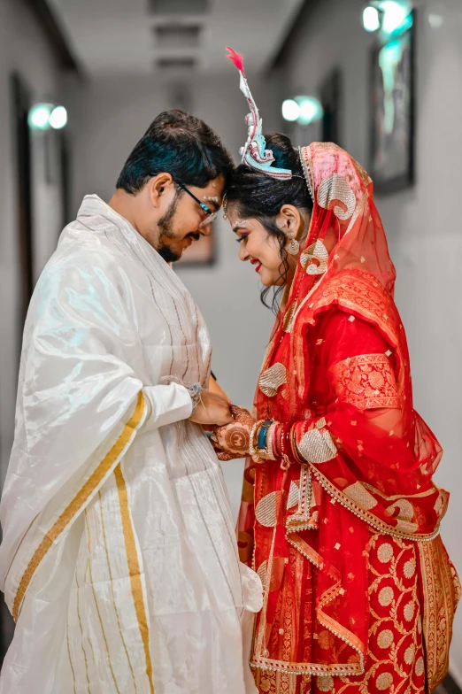 two people dressed in indian garb and holding each other