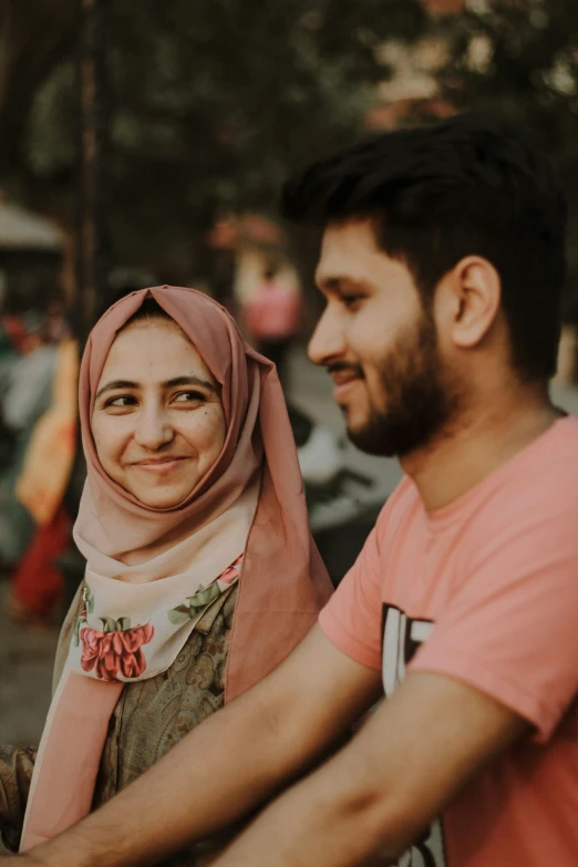 two people smiling for the camera at an outdoor event