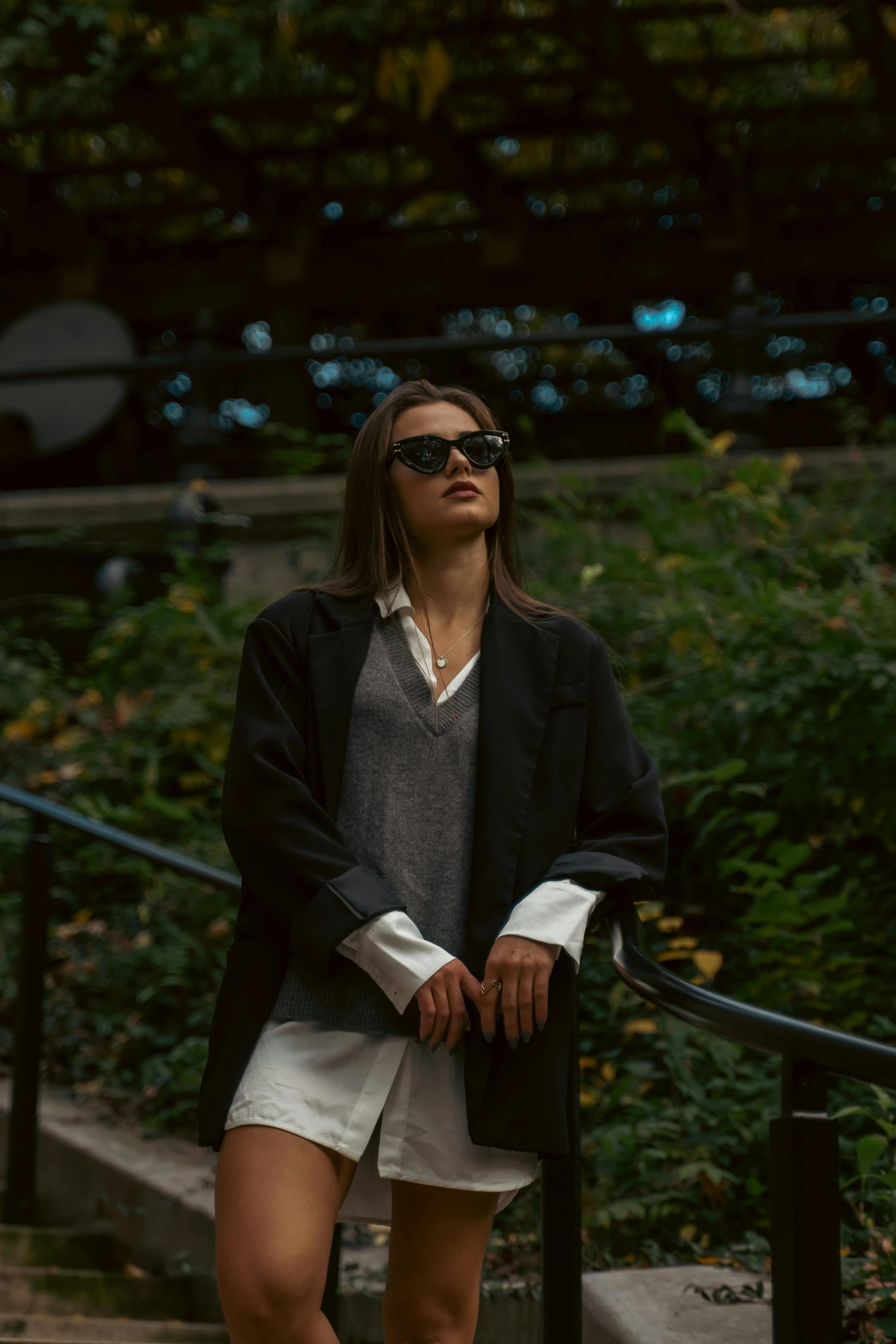 woman sitting on a hand rail with her eyes closed