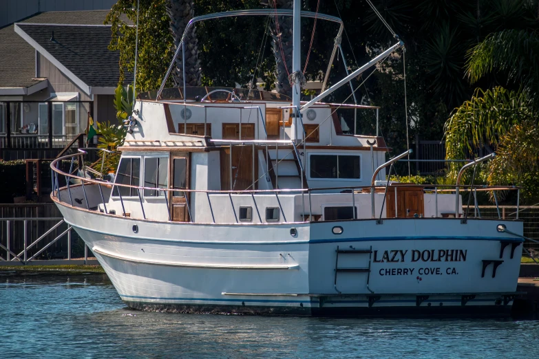 a large boat sits parked in the water by a marina