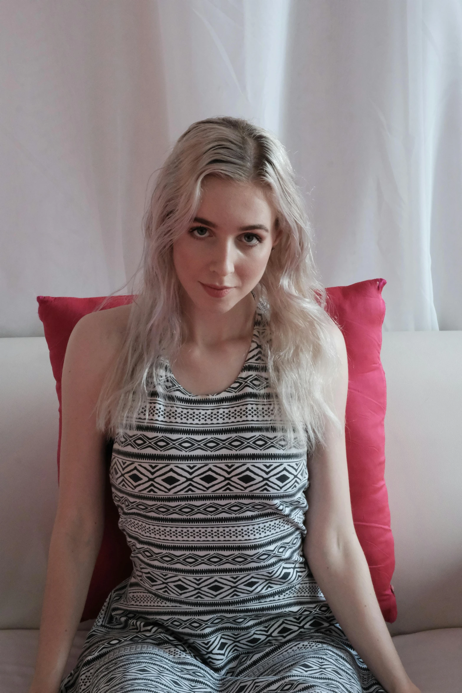 a woman with blond hair wearing pajamas and sitting on a sofa