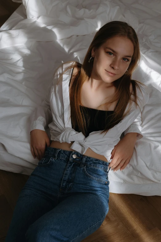 a woman is lying on her side while looking up from a bed