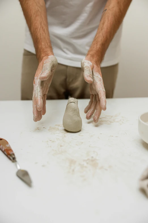 a man holding his hands near a piece of cement