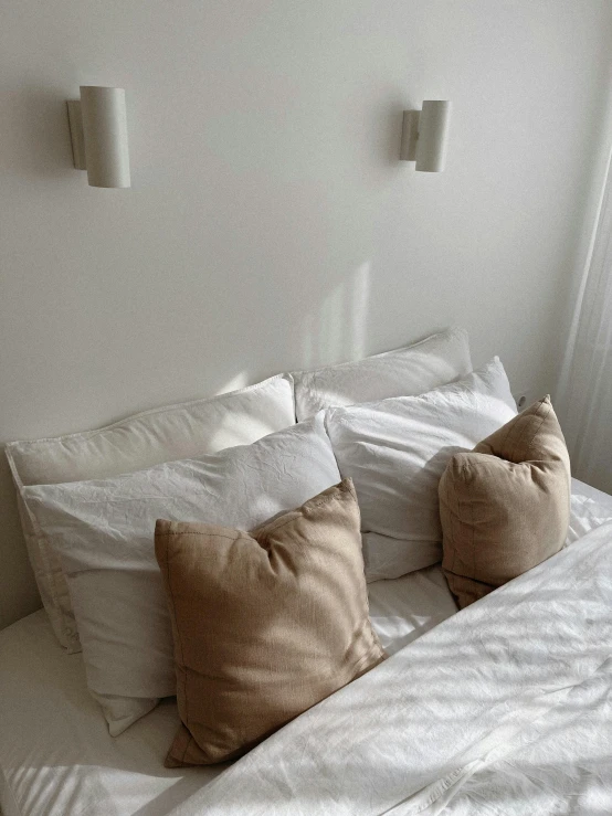 some pillows are laying on a bed that has been made