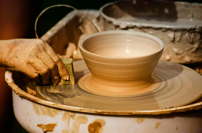 a person is spinning a pottery bowl on a wheel