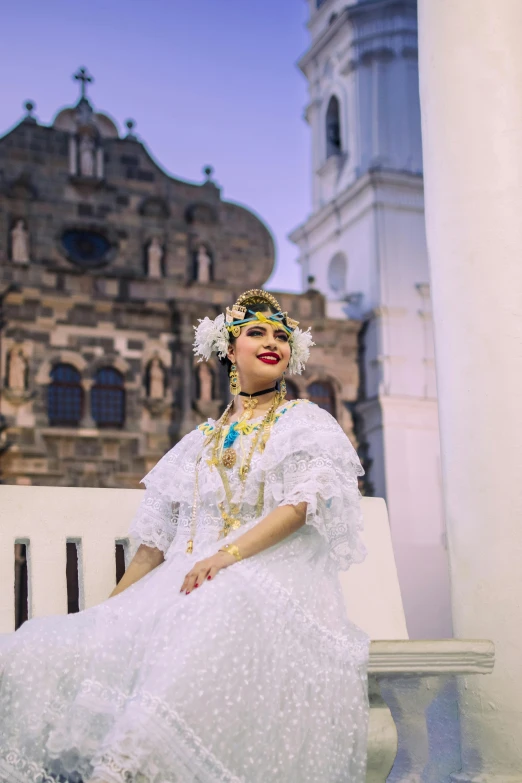 woman in traditional dress sitting on porch next to church