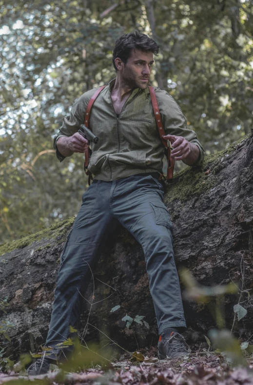 a man is wearing a backpack while standing on a log