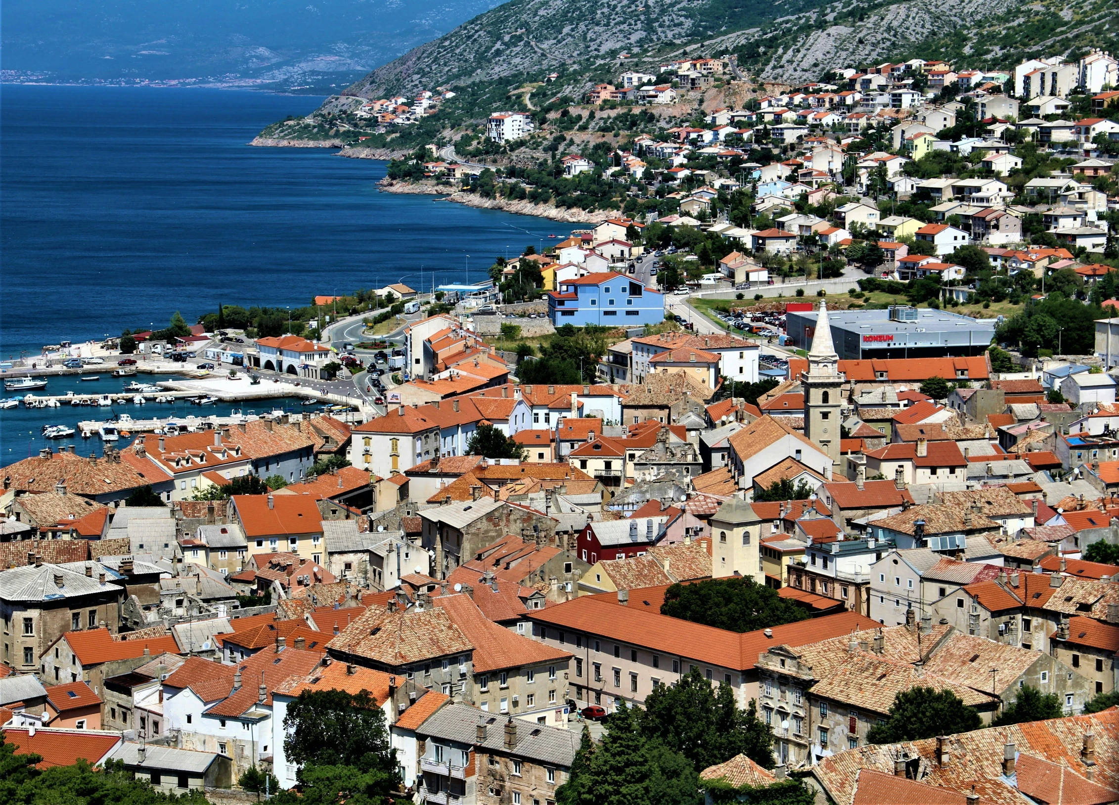 old city with red roofs near a body of water