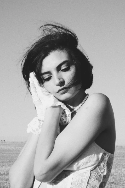 a woman sitting in the desert near grass