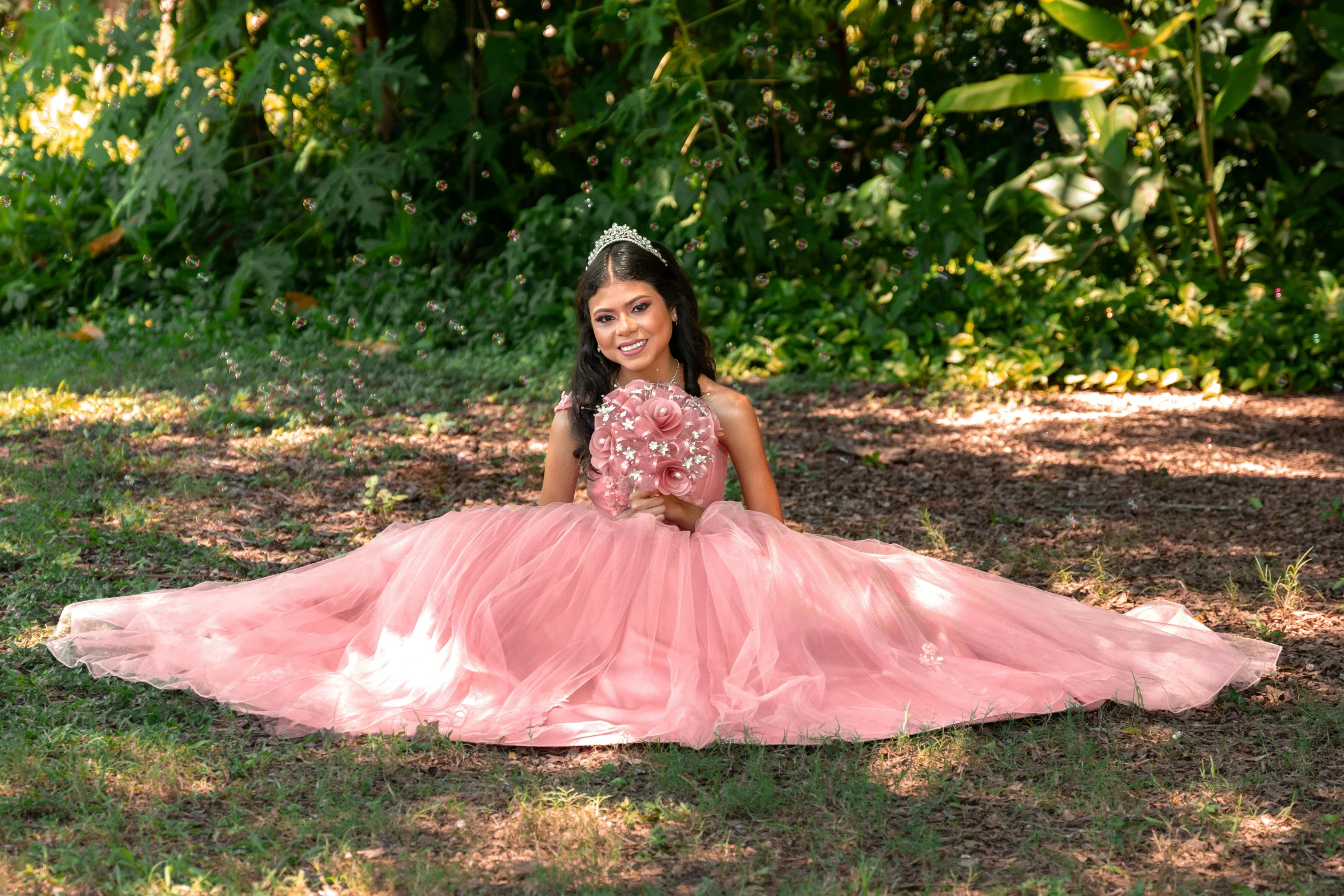 a  in a pink dress is sitting on the grass