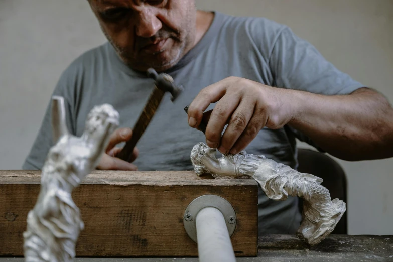 a man uses a pipe to create a wooden piece
