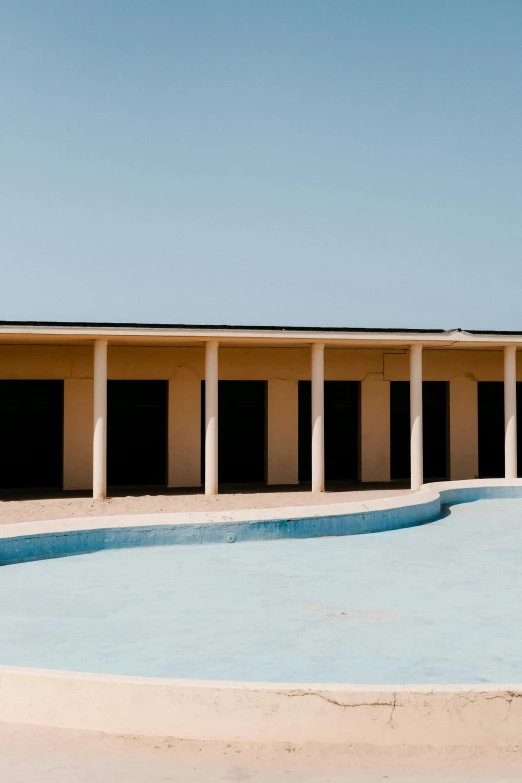 a empty pool in a cement area in front of a building
