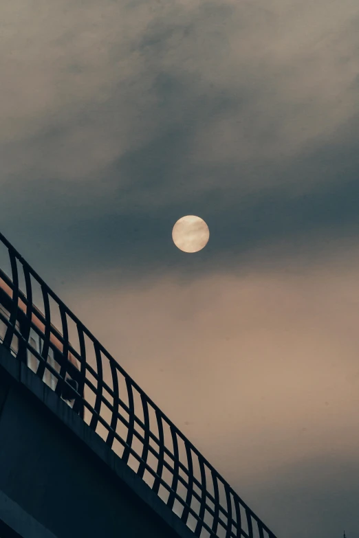 moonrise and the grey sky over an elevated bridge
