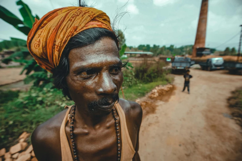 a man is covered in mud while a person walks behind him