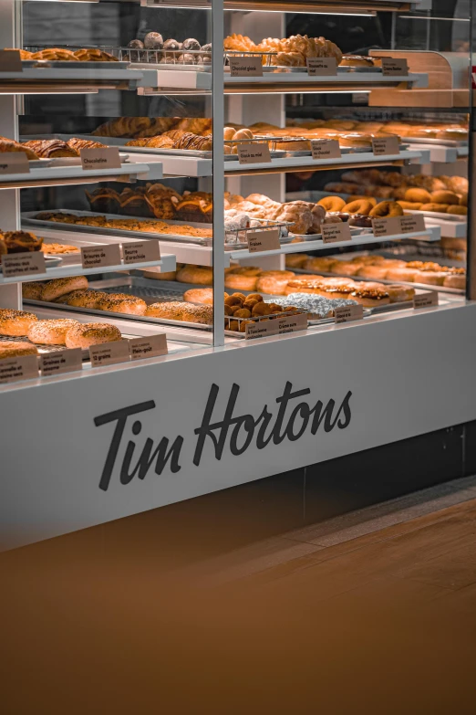 a display case filled with lots of donuts under glass