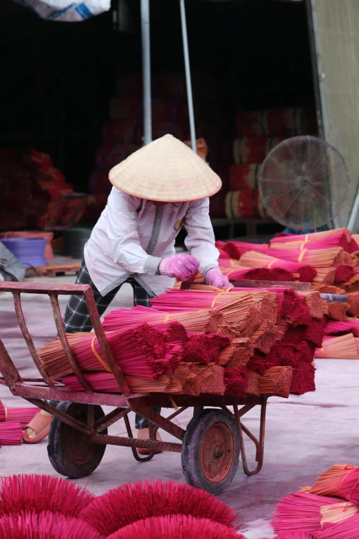 a man with a straw hat working on a cart