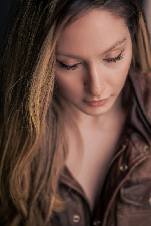 a woman wearing a brown shirt and holding her phone