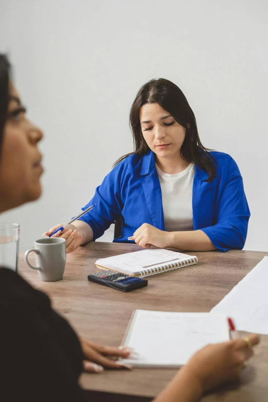 two women sitting around a table and having a conversation