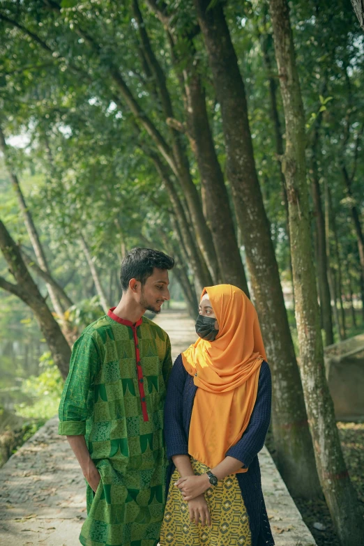 a couple in colorful clothing standing next to a walkway