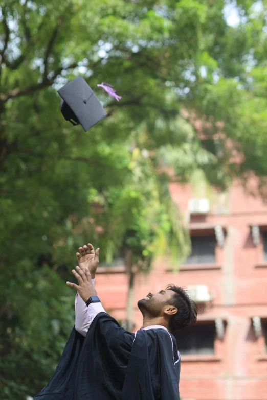 a graduate throws his hat into the air