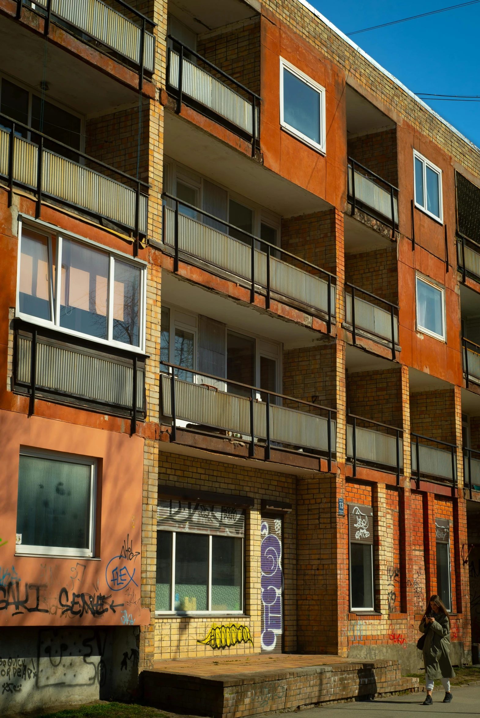 a person walking past the bottom floor of an apartment building