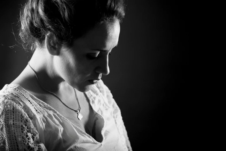 a woman that is wearing a necklace looking down