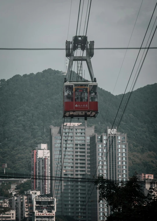 the people are riding the red cable car over the city