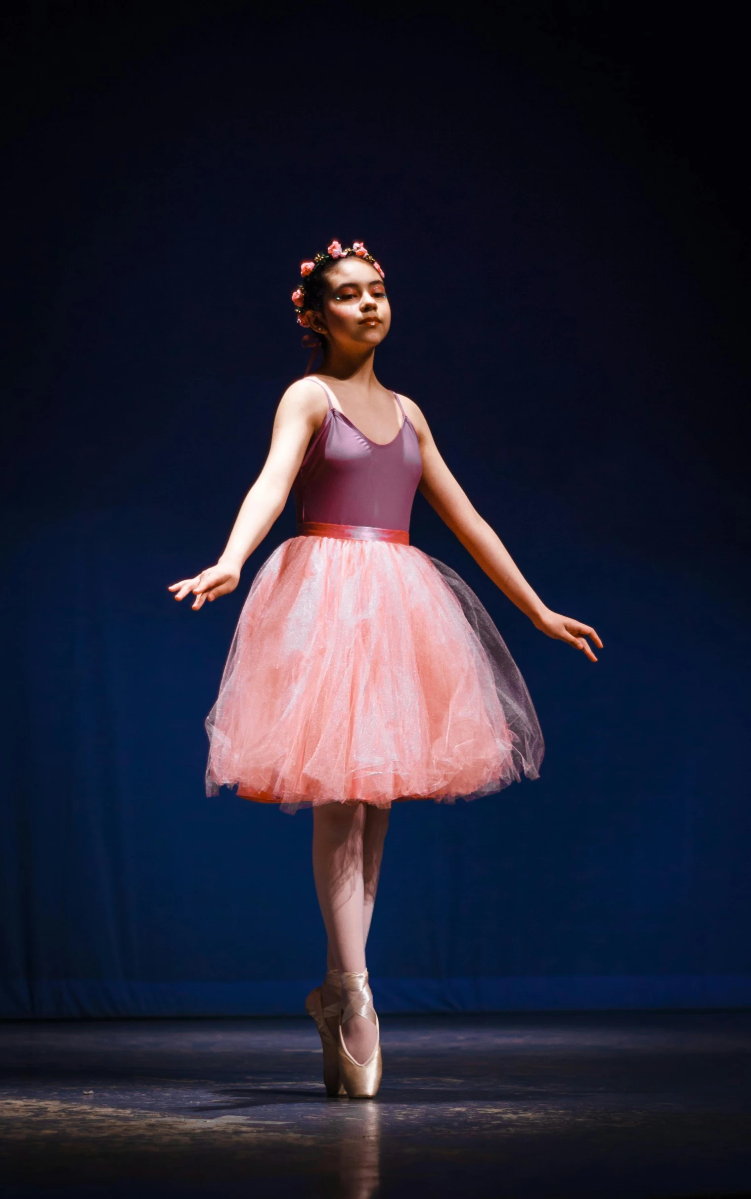 a young ballerina standing up in a ballet outfit