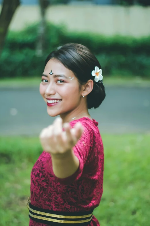 the asian woman is smiling and pointing with her fingers