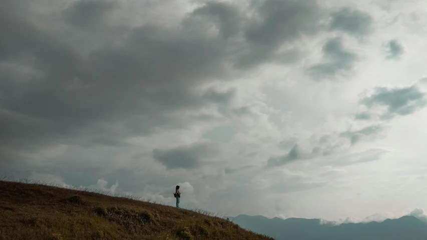 an empty field with a person walking up to the top of it