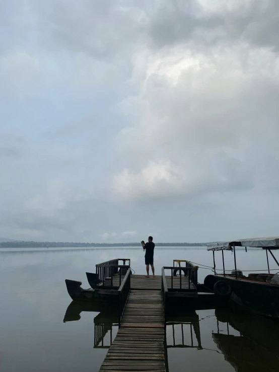 a person on the dock and fishing in the water