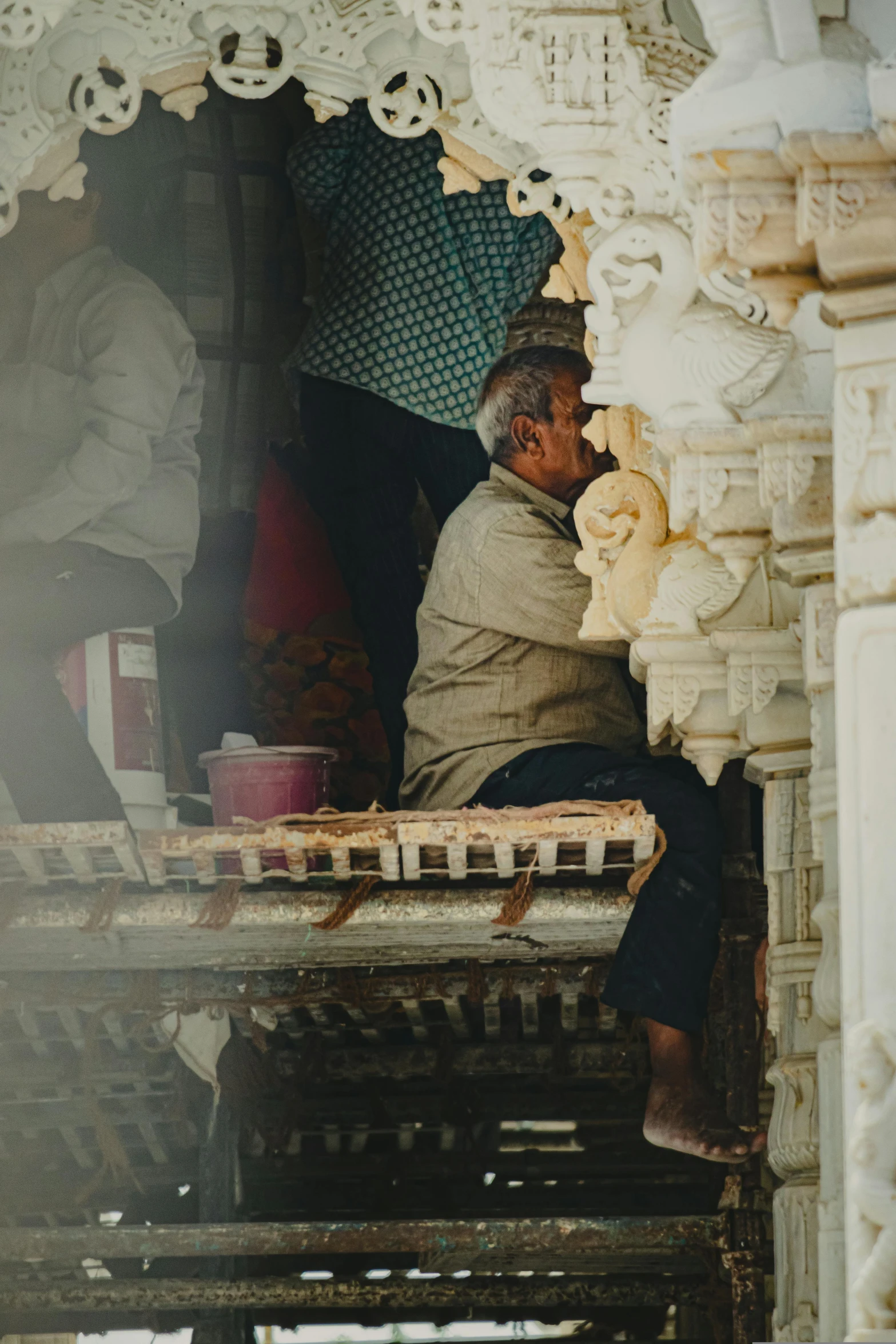 an old man is sitting outside with his umbrella