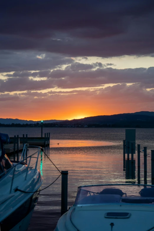 the sun is setting over boats docked in the water