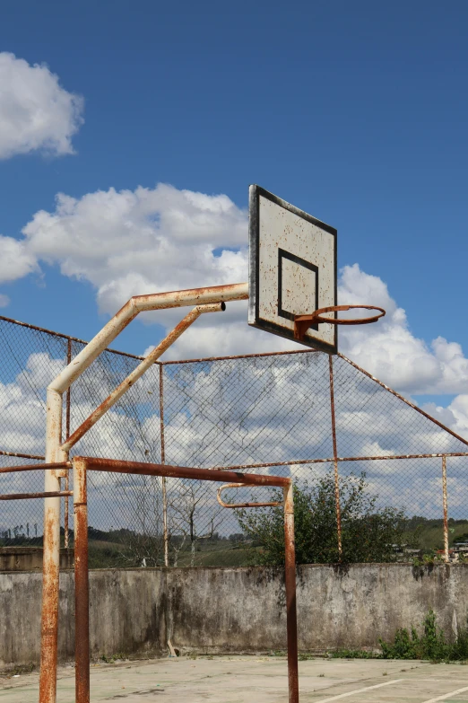 a basketball hoop near an old fence on a cloudy day