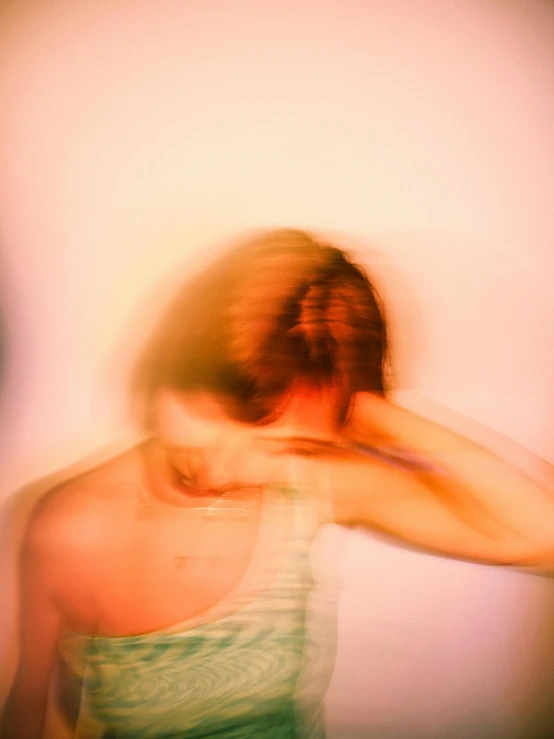 a young person leaning on a wall with their head on her hand