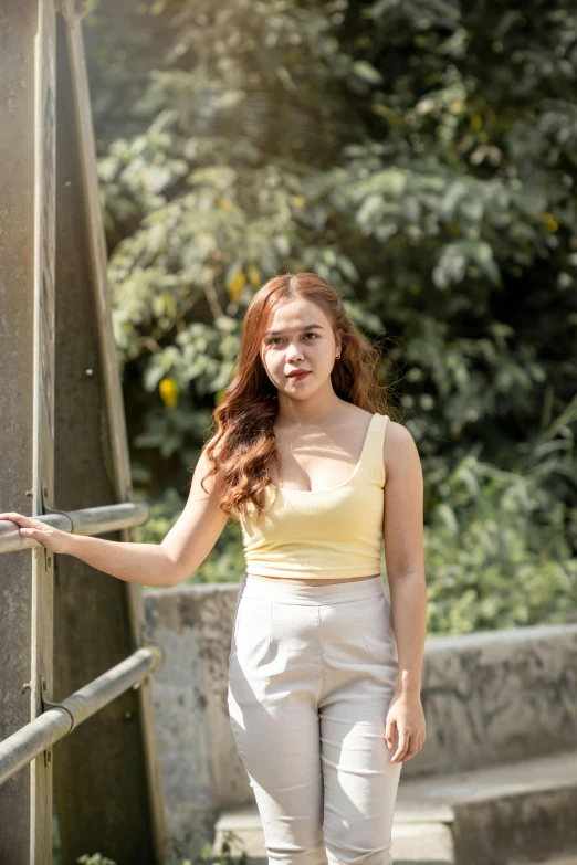 a woman posing on the stairs next to a fence