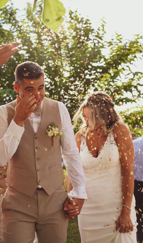 the newly married couple stand under confetti