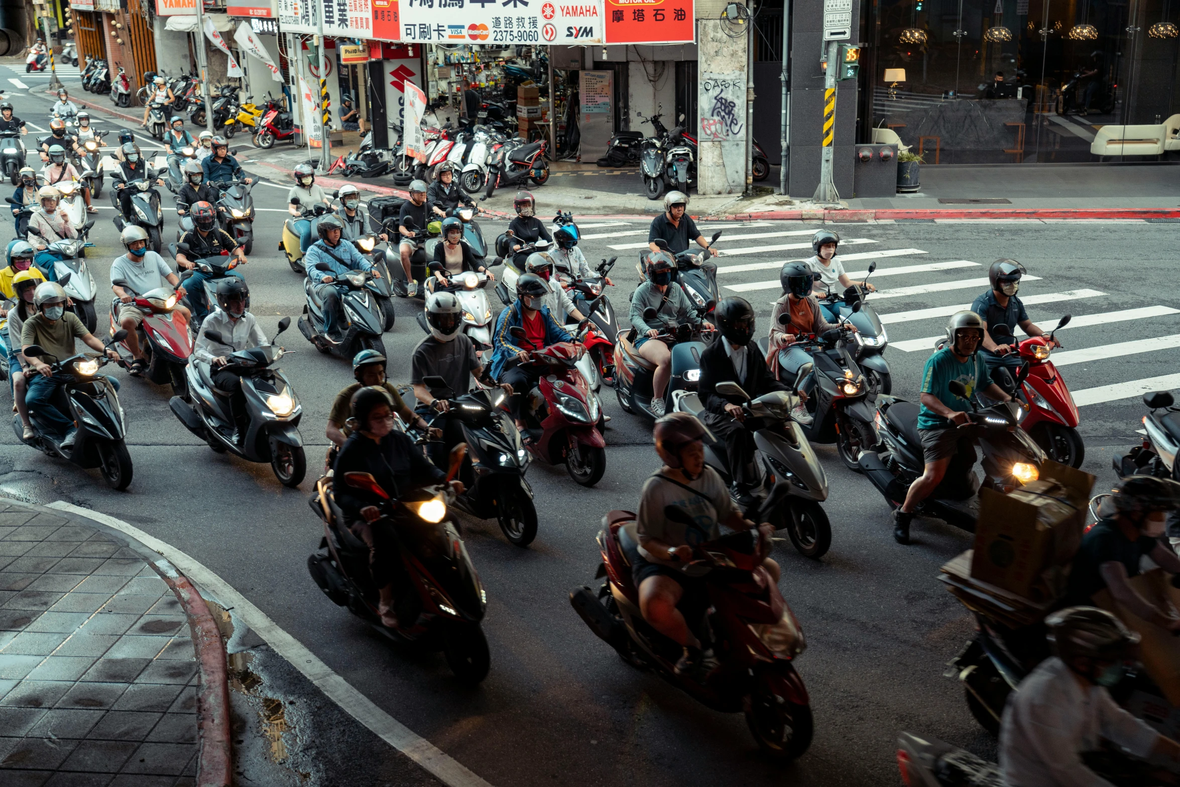 many motorbikes are traveling down the street in traffic