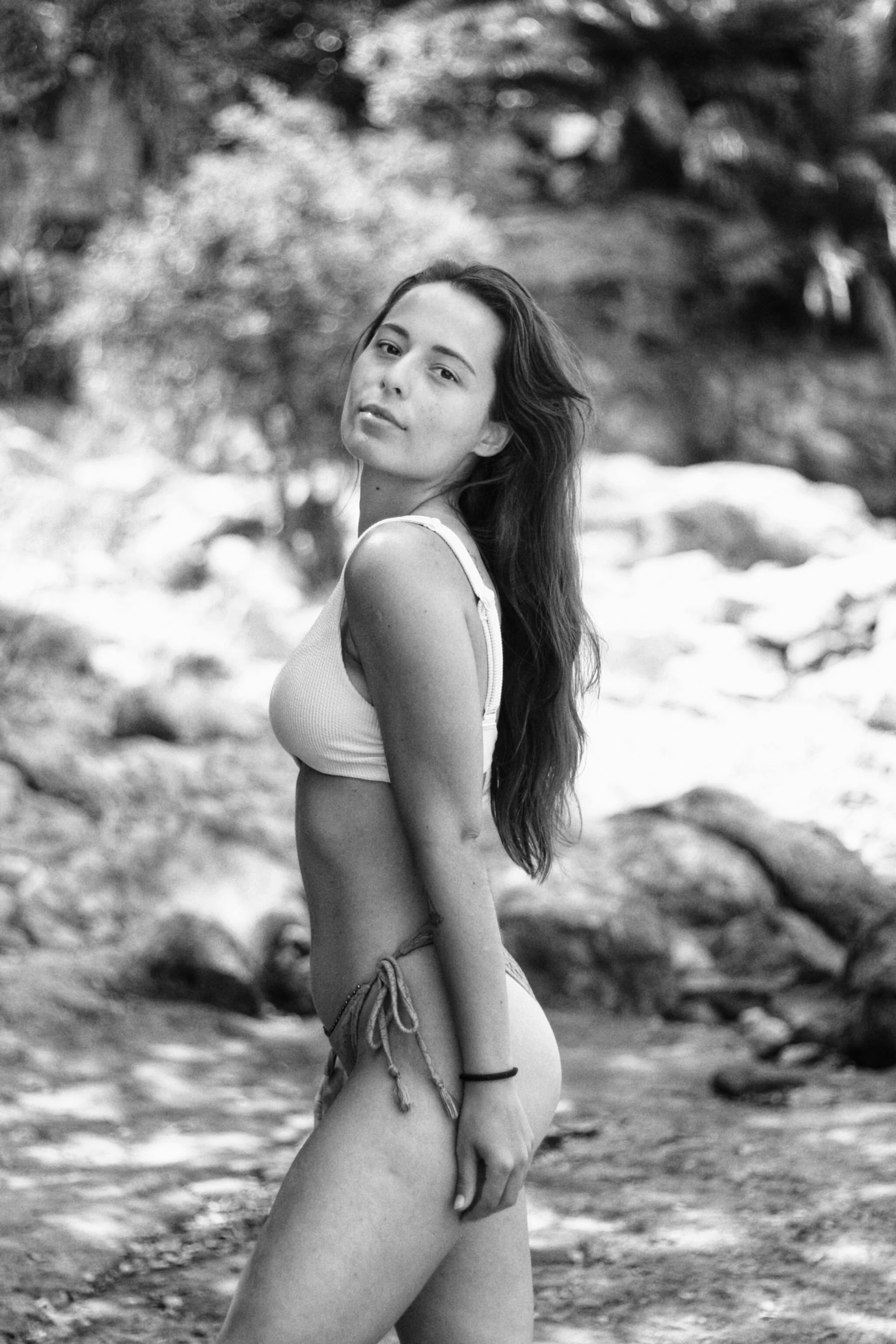 black and white po of woman standing on beach