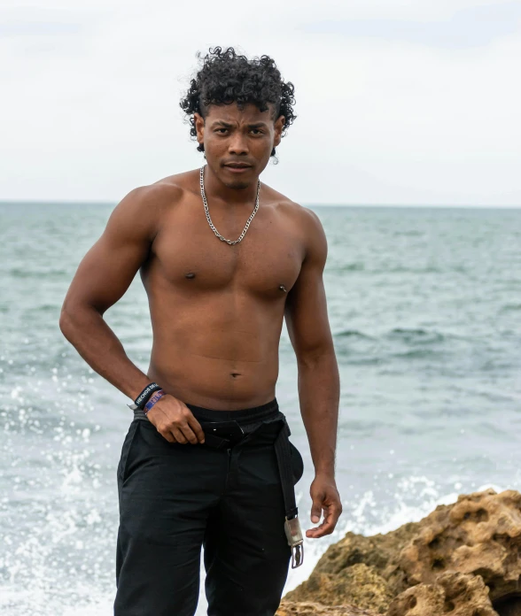 a man standing next to the ocean on a beach