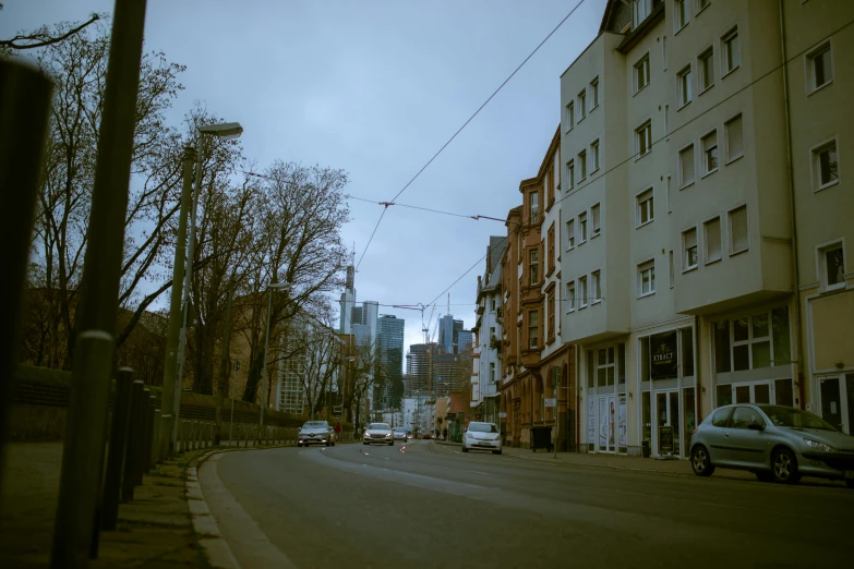 a couple cars parked along a narrow city street