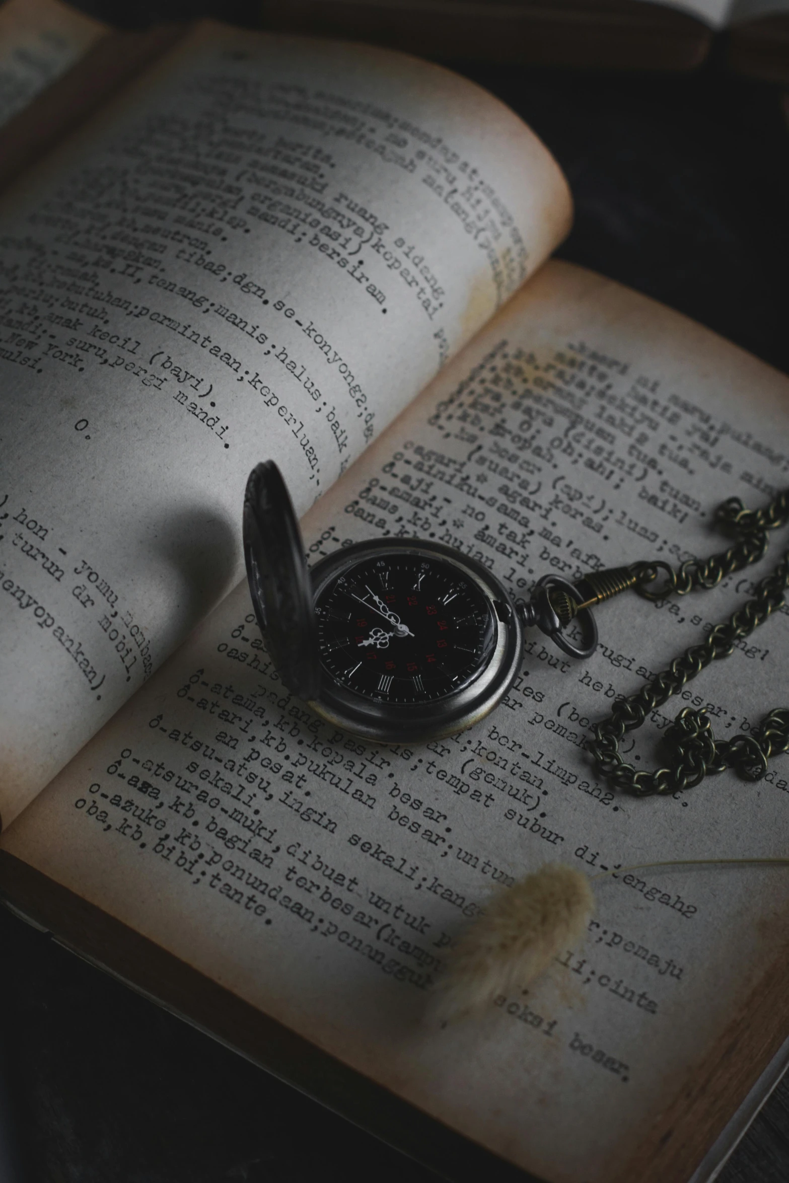 a pocket watch laying on an open book