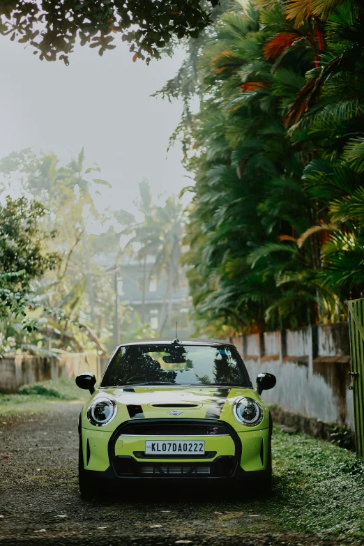 a bright yellow mini cooper on the side of the road