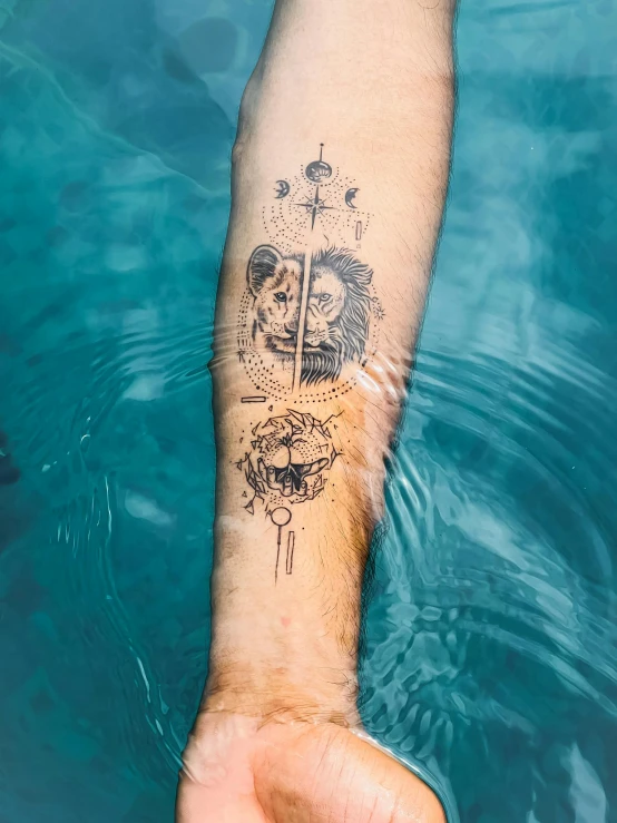 a hand with a tattoo that has water splashing out