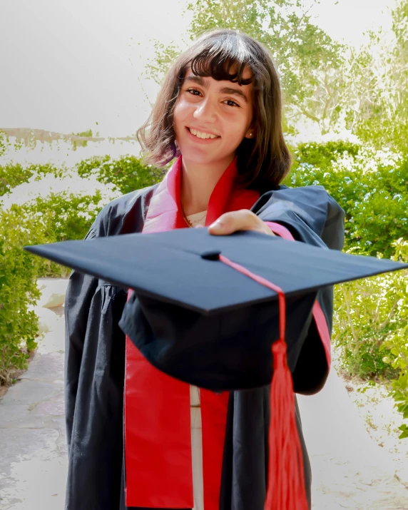 the female student is showing off her graduation cap and gown